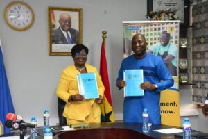 Shaibu Haruna, CEO of MobileMoney Limited (R) and COP Maame Yaa Tiwaa Addo-Danquah Executive Director of EOCO displaying the signed MOU